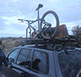 a revrack user, 40 something, stands next to the driverside door of a two thousand five hun die with a revrack carrying bikes and skis on top